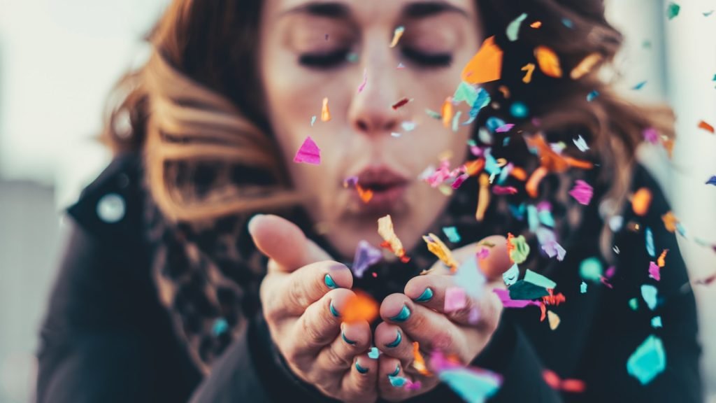 woman blowing paper strips. Wish